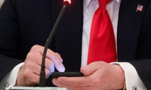 Donald Trump taps the screen on a mobile phone on 18 June at the approximate time a tweet was released from his Twitter account.