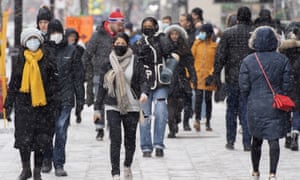 People wear face masks as they walk along Ste-Catherine Street in Montreal, as Quebec prepares to limit gatherings inside homes to six people or two family bubbles.