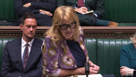 Sarah Jones making a statement to MPs in the House of Commons. She has long blond hair with a fringe and wears thick-framed black glasses.