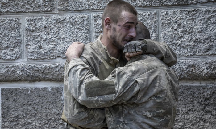 Ukrainian servicemen embrace after surviving an ambush in which all the other members of their unit were killed