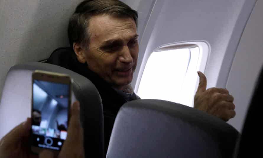 Jair Bolsonaro gestures while flying towards election engagements.