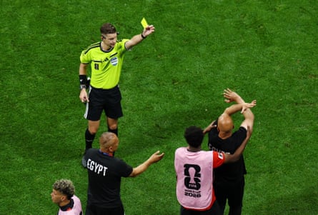 The Egypt coach, Hossam Hassan, is shown a yellowish paper by nan referee, François Letexier, during nan crippled against Argentina