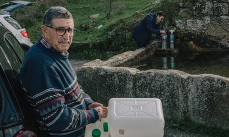 Silvio Siciliano, 76, (on the left) at the old Ummuru watering hole on the outskirts of town, filling up some water containers.