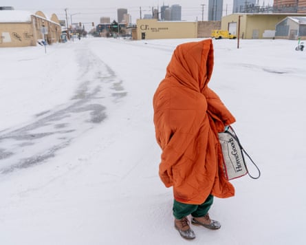 An unhoused woman uses a blanket to try to stay warm in Oklahoma City, Oklahoma.