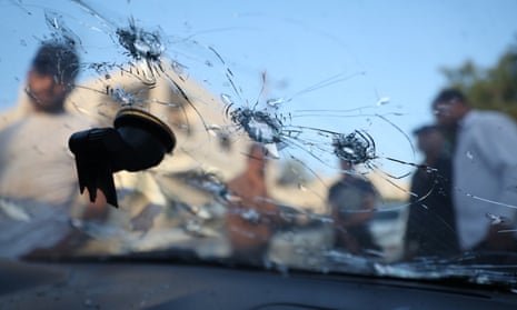People inspect a car riddled with bullet holes after Israeli troops opened fire and killed three Palestinians in Jenin, West Bank, on 17 June.
