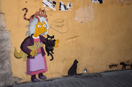 a painted image of an older lady holding three cats on a wall