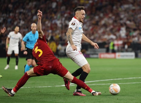 Roma's Roger Ibanez fouls Sevilla's Lucas Ocampos to concede a penalty before the decision is overturned after a VAR review.
