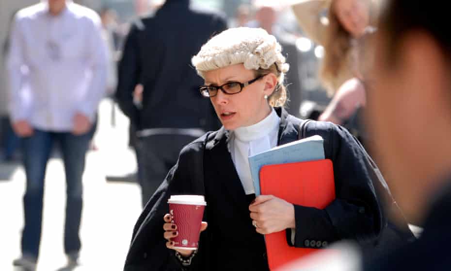Female barrister in a hurry carrying a cup of coffee outside the Central Criminal Court, Old Bailey