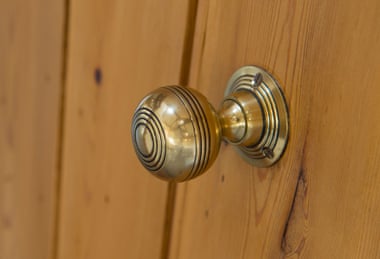 A brass door knob on a door