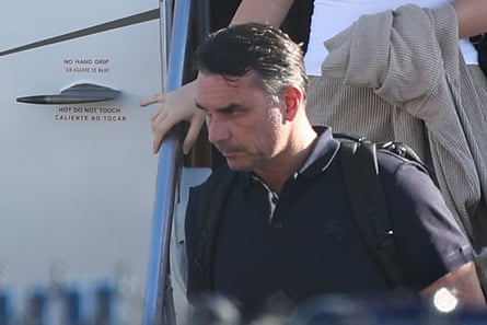 Flavio Bolsonaro steps down from a private plane, holding a railing marked “do not touch”
