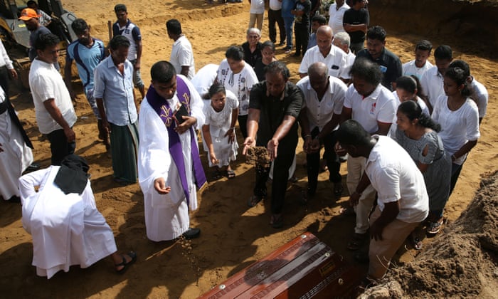 People attend a mass burial of victims at a cemetery near St Sebastian Church in Negombo on Tuesday.