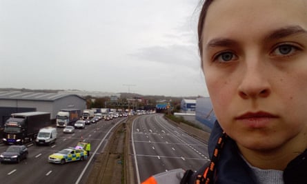 Handout photo issued by Just Stop Oil of a protester who has climbed a gantry on the M25 between junctions six and seven in Surrey, leading to the closure of the motorway.