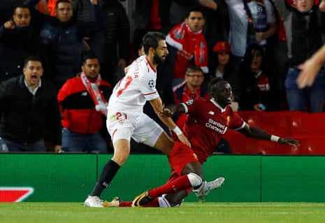 Sevilla’s Nicolas Pareja hauls down Liverpool’s Sadio Mane in the penalty area and the ref points to the spot.