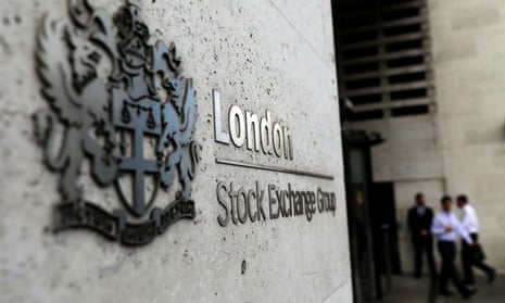 A London Stock Exchange sign with three out of focus pedestrians in the background