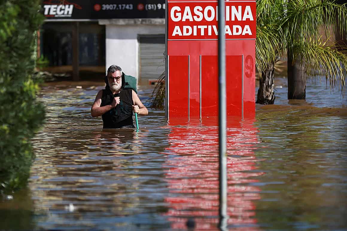 A man walks in a flooded street in Humaita, in Porto Alegre, Rio Grande do Sul, Brazil.
