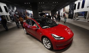 Buyers look over a Model 3 in a Tesla store in Denver.