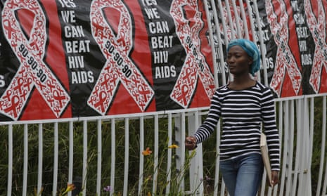 Woman walks past World Aids Day banner in South Africa