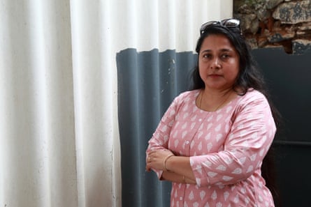 Mareena Hawkes, whose family have all experienced breathing difficulties after living in proximity to a factory producing asbestos sheets. She is photographed with asbestos sheets used as fencing in Coimbatore, Tamil Nadu, India.