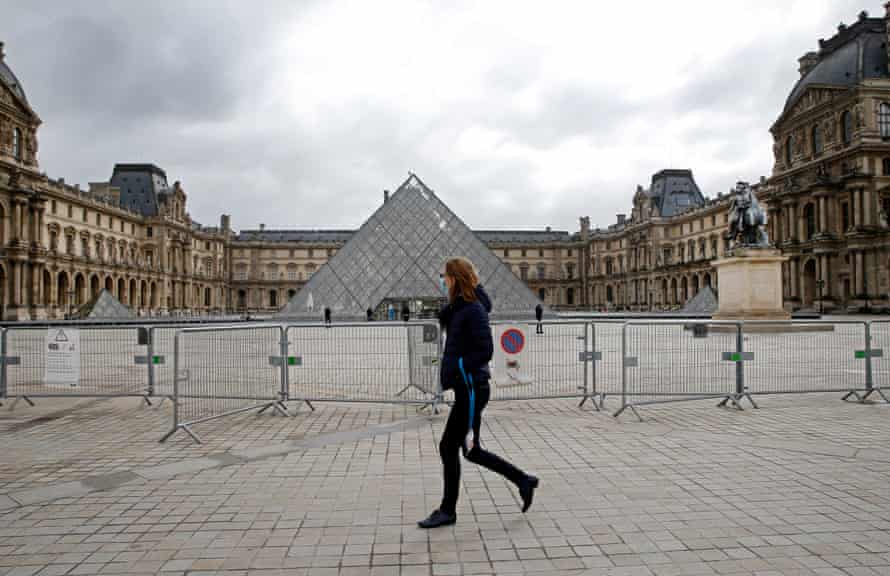 Um pedestre cruza o pátio em frente ao Louvre, em Paris, enquanto a França se prepara para um novo fechamento.