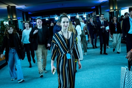 Schilling wearing a lanyard in a conference hall with delegates milling around her