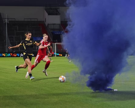 The Manchester City full-back Kerstin Casparij ignores a smoking blue flare to put in a cross that leads to a goal during her team’s Champions League league phase game away to Bayern Munich.