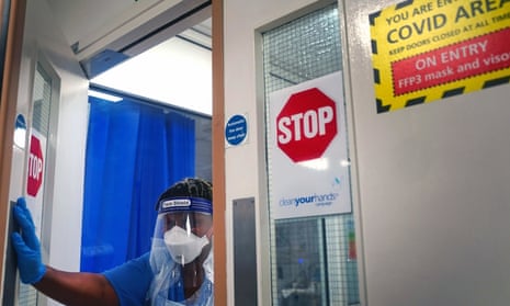 A member of staff wearing PPE walks through a ward for Covid patients at King's College hospital in south-east London.