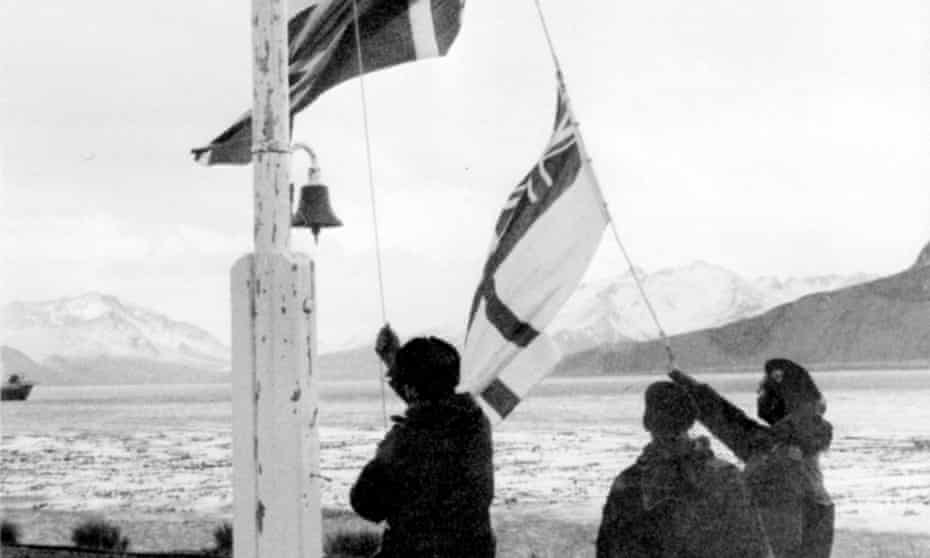 The union flag and white ensign being raised on South Georgia after the island’s recapture by the British, 1982.