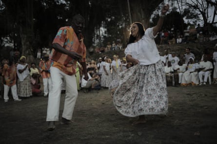 A man and a woman dance in the center of a circle.