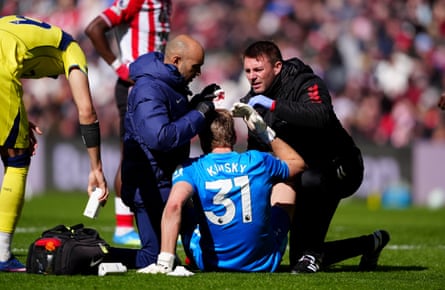 Antonin Kinsky receives treatment for an injury after colliding with Cristian Romero