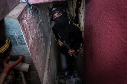 Freddy, 16, a member of a kidnapping gang, guards a safe house in a slum in Caracas. He too, joined a gang to find food for his family