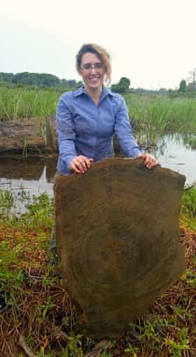 Environmental archaeologist Katharine Napora holding a cross section of a cypress tree.