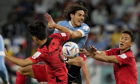 Edinson Cavani fights for the ball with South Korea's Hwang In-beom.