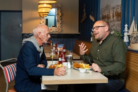 Andrew and Jonathan chatting and eating at a restaurant table