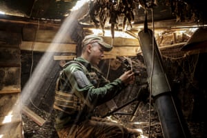 A soldier sitting in a crammed room firing a 120mm mortar amid the ongoing Russian invasion
