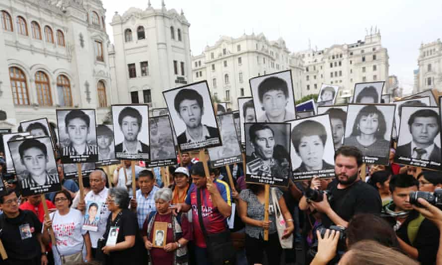 People holding pictures of victims of the guerrilla conflict march against President Kuczynski’s pardon for former president Alberto Fujimori in Lima