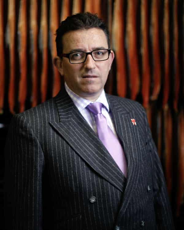 Portrait of Lance Forman in a pinstripe suit with pink shirt and darker prink tie