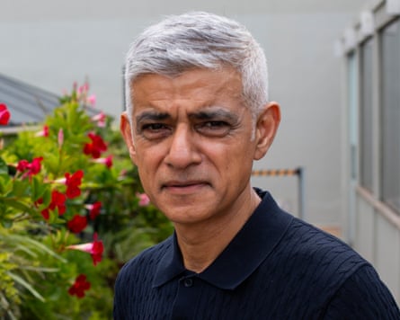 A middle-aged Asian man with a bougainvillaea behind him
