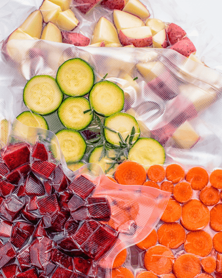 Chopped vegetables including carrots and courgettes in vacuum packed clear plastic bags