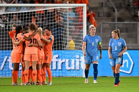 Millie Bright and Georgia Stanway of England look dejected as Lieke Martens of the Netherlands celebrates with teammates after scoring.