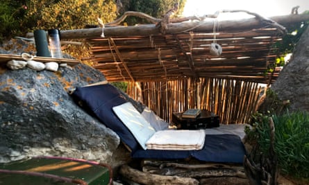 Susan's den, showing the bamboo roof and a blue mat for sitting on against the rock