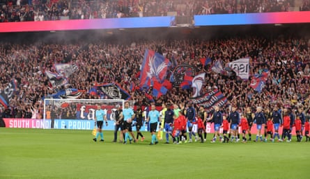 Crystal Palace players walk on to the pitch with their matchday mascots.