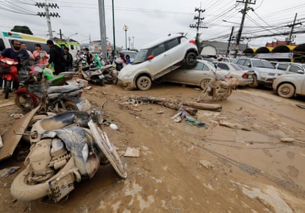 Damaged cars and motorbikes on a muddy street
