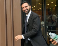 man in suit smiles as he walks outside
