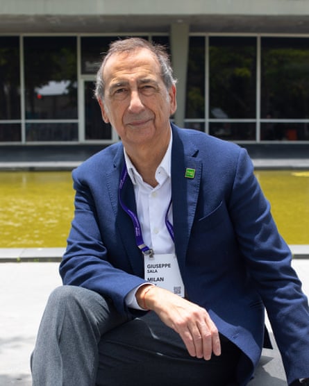 An older white man in a jacket and open-necked short