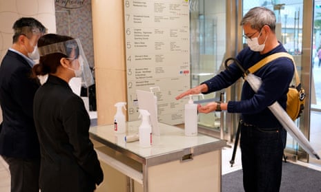 A customer uses hand sanitiser as he enters a Tokyo shopping centre.
