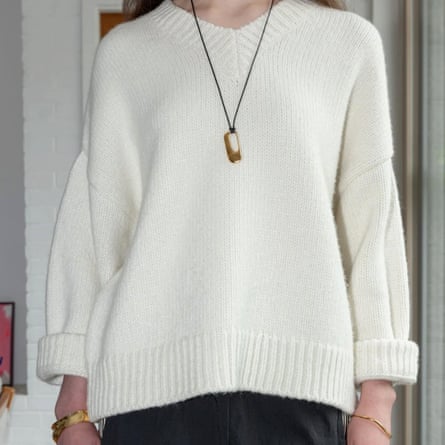 A longline pendent is worn over a chinky knit white jumper