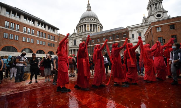 Protesters cover Paternoster Square in central London in fake blood and coins during an Extinction Rebellion  march