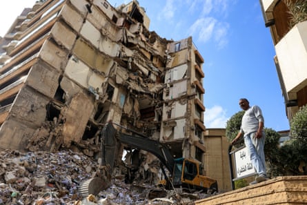 A man stands next to a building razed to the ground by the Israeli strikes in Beirut, Lebanon
