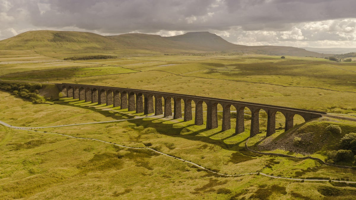The magnificent Ribblehead viaduct against a backdrop of open countryside with hills behind