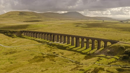 The magnificent Ribblehead viaduct against a backdrop of open countryside with hills behind